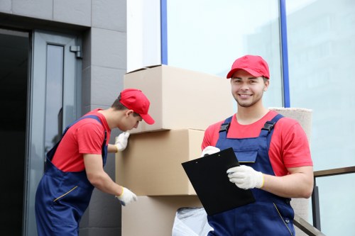 Moving crew handling office furniture during a Belsizepark relocation