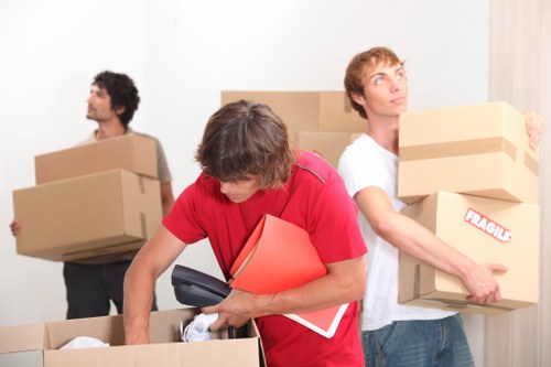 Moving professionals handling office furniture in a Belsizepark property
